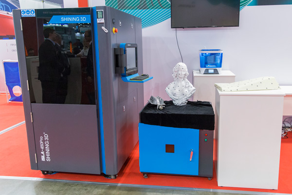 Принтер Shining 3D iSLA-450 Pro (слева) на выставочном стенде компании «Диполь»